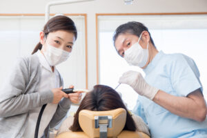 歯科治療をしている歯科医師と歯科衛生士