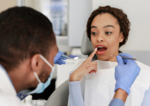 患者が指をさす歯を見る医師