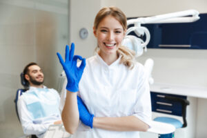 OKサインの女性歯科医と笑顔の患者