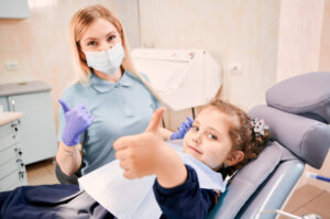 親指を立てる歯科医と女の子
