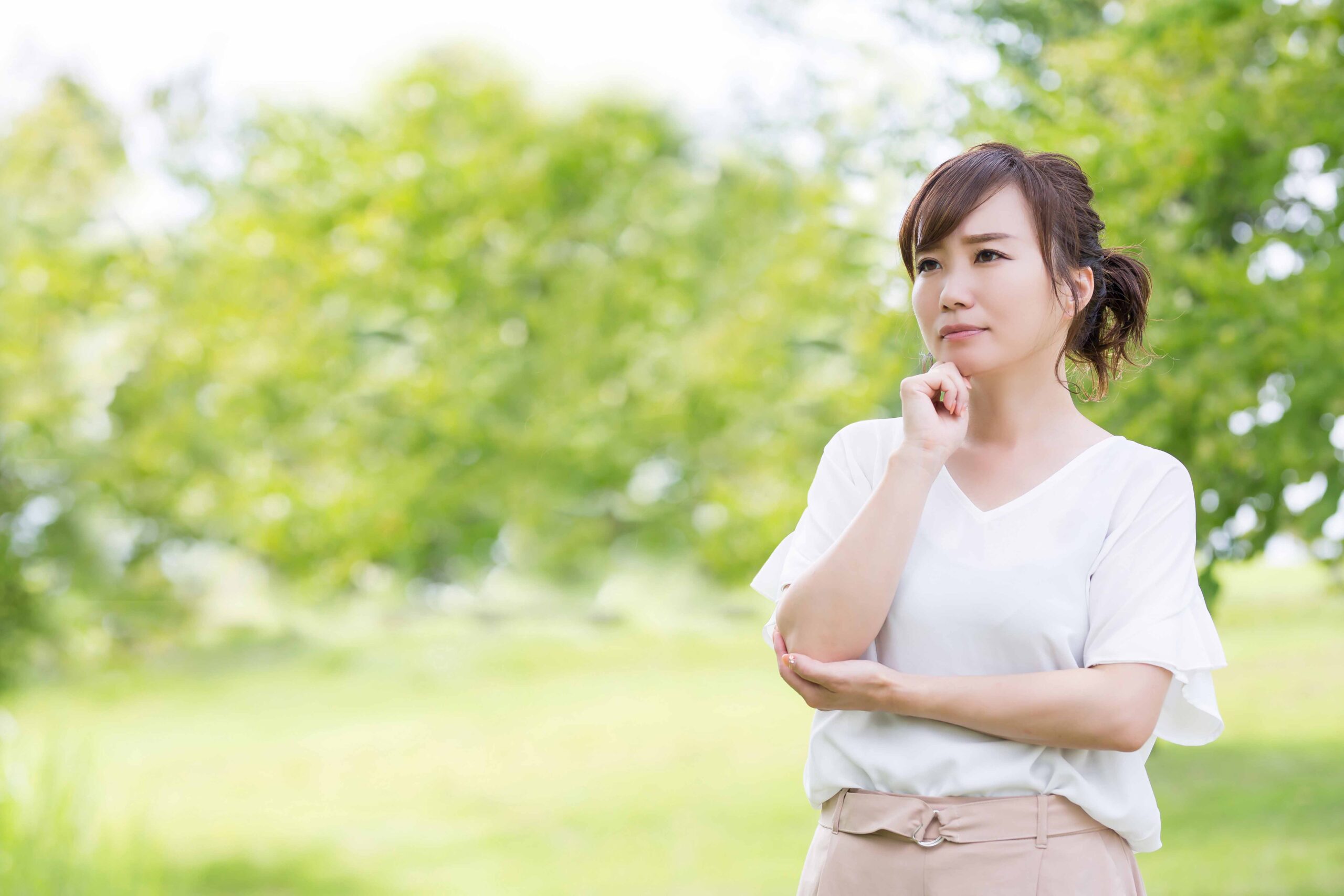 顎に手を当てて悩んでいる女性
