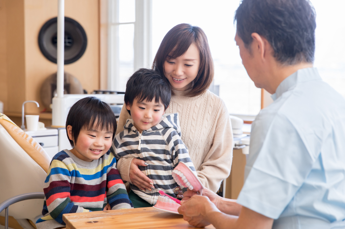 3名の親子と歯科医師が会話している